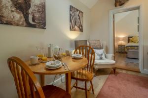 uma sala de jantar com uma mesa de madeira e cadeiras em The Lodge, Wherstead 