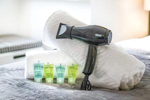 a blow dryer sitting on top of a bed at Stylish 2 Bedroom 2 Bathroom Apartment - 8 Minutes Drive to Central MK - Free Parking, Fast WiFi & Smart TV by Yoko Property in Milton Keynes