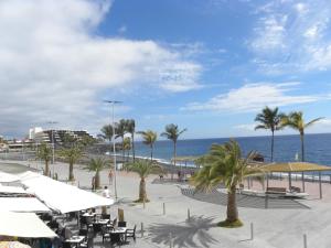 una playa con mesas, palmeras y el océano en Apartamento Atlántico Playa 1, en Puerto Naos 16 fotos más