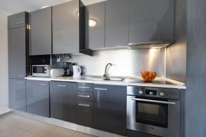 a kitchen with stainless steel cabinets and a sink at Paraiso a Beira Mar -Sol e Praia in Portimão