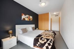 a bedroom with a white bed with a black wall at Paraiso a Beira Mar -Sol e Praia in Portimão +18 photos