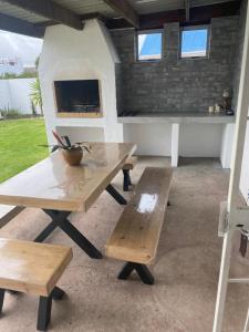 a picnic table with two benches in a patio at 5 bedroom home in Langebaan, located close to Club Mykonos and Laguna Mall in Langebaan