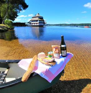 a table with a bottle of wine and bread and a bottle of beer at Les roulottes de cirque Les Settons in Moux-en-Morvan