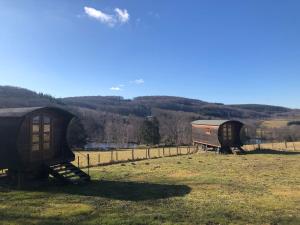a couple of small buildings sitting in a field at Les roulottes de cirque Les Settons in Moux-en-Morvan