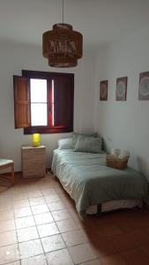 1 dormitorio con cama y ventana en La Casa de la Lobita, en Benaocaz