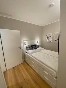 杜塞道夫的住宿－Zentrales Appartment mit großer moderner Küche EG2，一间铺有木地板的白色卧室,配有一张床