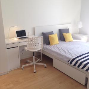 ビャウィストクにあるApartament LIZBONAのベッドルーム1室(ベッド1台、デスク、ノートパソコン付)