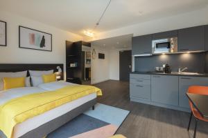 a bedroom with a king sized bed and a kitchen at acora Berlin Living the City in Berlin