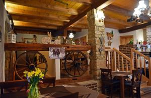 a dining room with a woodenoked wheel and a table at Penzion Tuček Adršpach in Adršpach