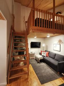 a living room with a couch and a loft at Winter Nest - A cozy accommodation in the heart of Saariselkä in Saariselka