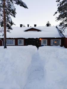 uma casa coberta de neve com uma entrada em Winter Nest - A cozy accommodation in the heart of Saariselkä em Saariselka