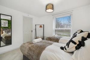 - une chambre blanche avec 2 lits et une fenêtre dans l'établissement Stylish 2 Bedroom 2 Bathroom Apartment - 8 Minutes Drive to Central MK - Free Parking, Fast WiFi & Smart TV by Yoko Property, à Milton Keynes