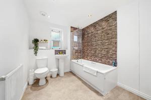 a bathroom with a toilet and a tub and a sink at Stylish 2 Bedroom 2 Bathroom Apartment - 8 Minutes Drive to Central MK - Free Parking, Fast WiFi & Smart TV by Yoko Property in Milton Keynes