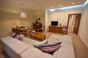 a living room with a white couch and a table at Piccola Perla sul Lago Maggiore in Arona