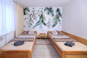 3 łóżka w pokoju z malowidłem ściennym w obiekcie Apartamenty Częstochowa w mieście Częstochowa