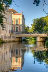 a bridge over a river in front of a building at Beautiful large stylish villa centrally located in Pons in Pons