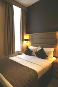 a hotel room with a bed and two lamps at Lord Jim Hotel London Kensington in London