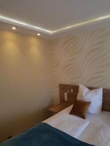 1 dormitorio con 1 cama con sábanas y almohadas blancas en FeWo Nina Exklusiv Design mit Bergblick, en Goslar