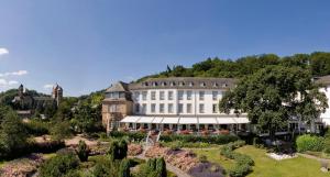 a large building with a garden in front of it at Seehotel Maria Laach in Maria Laach