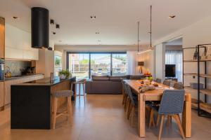 a kitchen and living room with a large wooden table at Arivallos Villa & SPA with Sauna and Wine Cellar in Litherés