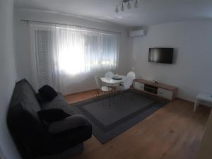 a living room with a couch and a table at DALMAR Apartman in Bihać