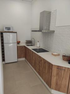 a kitchen with wooden cabinets and a white refrigerator at APARTAMENTO TURISTICO LEO BAENA in Baena