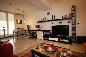 ein Wohnzimmer mit einem großen TV und einem Tisch in der Unterkunft Bali Loft Savona Albissola in Savona