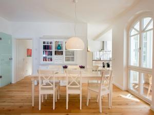 uma sala de jantar branca com uma mesa e cadeiras brancas em Villa Fabiola in Strandnähe em Binz