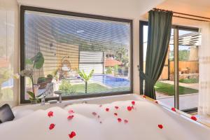 a bedroom with a tub with red rose petals on it at Flower Hotel Patara in Patara