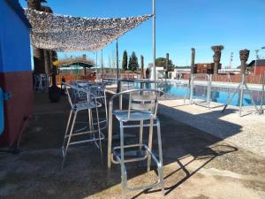 un grupo de taburetes sentados junto a una piscina en Caserío de Vazquez 3, en Castilblanco de los Arroyos