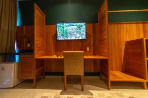 a room with a desk with a television on the wall at Hotel da Praça in Bonito