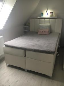 Bett in einem kleinen Zimmer unter einer Treppe in der Unterkunft Ferienwohnung Meeresbrise in Aventoft