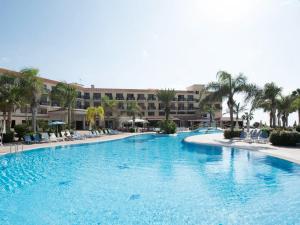 a large swimming pool with a resort in the background at Anmaria Beach Hotel & Spa in Ayia Napa