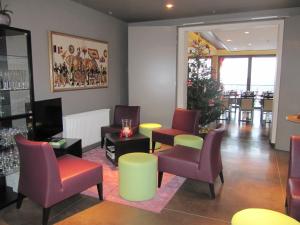 een wachtkamer met stoelen en een tafel en een tafel bij La Fête au Palais in Lustin
