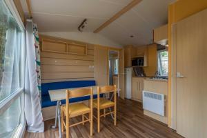 uma cozinha com mesa e cadeiras num quarto em Camping-Gites Au songe du Valier em Seix