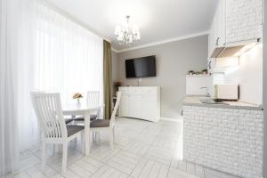 a kitchen and dining room with a table and chairs at Apartments Park Fountains in Liski