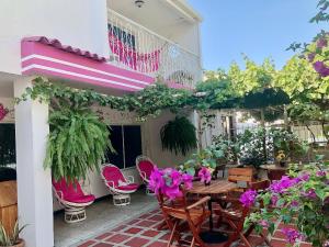 un patio con mesa, sillas y flores en Casa Hospedaje Villaluz- a 5 minutos de la Playa, en Santa Marta
