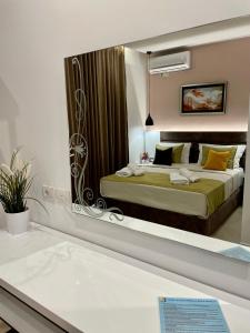ein Spiegelreflex aus einem Schlafzimmer mit einem Bett in der Unterkunft Relax Apts Saranda in Sarandë