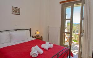 a bedroom with a red bed with towels on it at To Pithari in Skiros