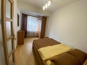 1 dormitorio con cama, ventana y puerta en Northern Avenue Apartment, en Ereván