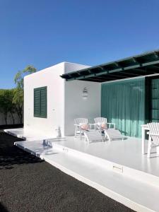 un patio blanco con sillas blancas y una mesa en CASA TAMATINA by Villitas, en Playa Blanca