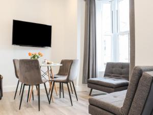 a living room with a table and chairs and a tv at Baker Chambers in Camborne