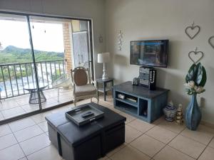 a living room with a tv and a couch and a table at 305 Hawaan View in Durban
