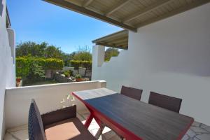 a wooden table and chairs on a balcony at To Pithari in Skiros