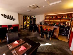 a restaurant with tables and chairs and a bar at Maryfield House Hotel in Lerwick