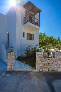 a white building with a balcony on top of it at To Pithari in Skiros