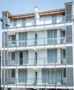 un edificio de apartamentos blanco con balcones y luz de la calle en Alfa Bicocca Apartments, en Milán