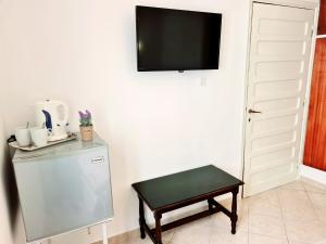 a room with a refrigerator and a table and a tv at Avra Rooms in Karpathos