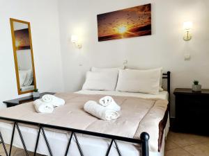 1 dormitorio con 1 cama con toallas en Avra Rooms, en Karpathos