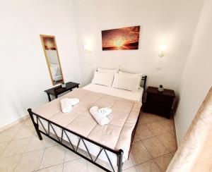 una camera da letto con un letto e asciugamani di Avra Rooms a Karpathos